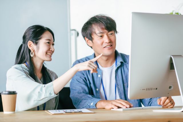 デスクトップPCを眺める男女
