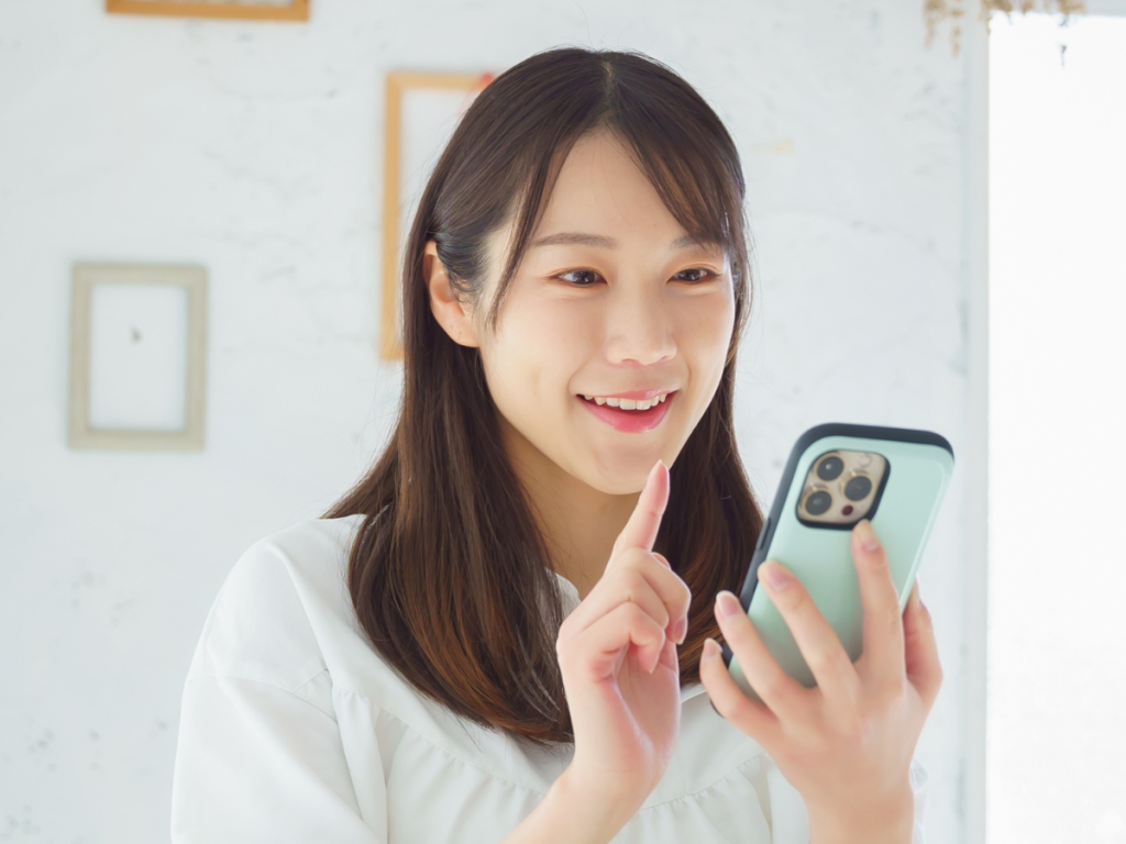 楽しそうにスマホをタップする女性