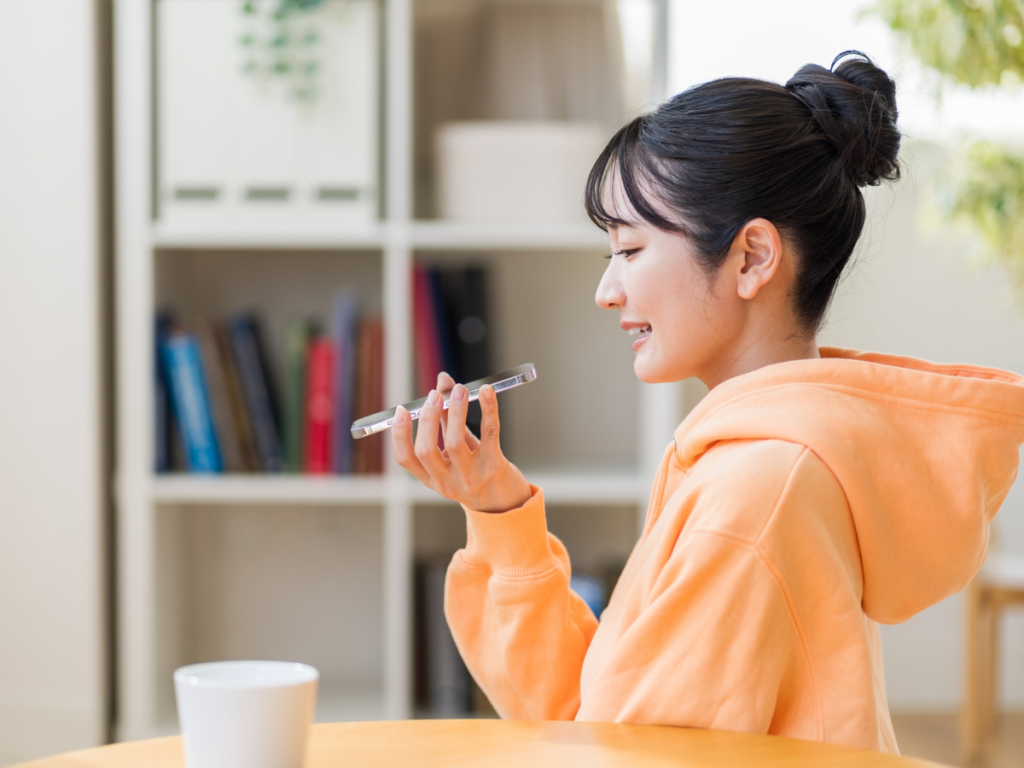 スマートフォンでシャドーイングする20代の女性