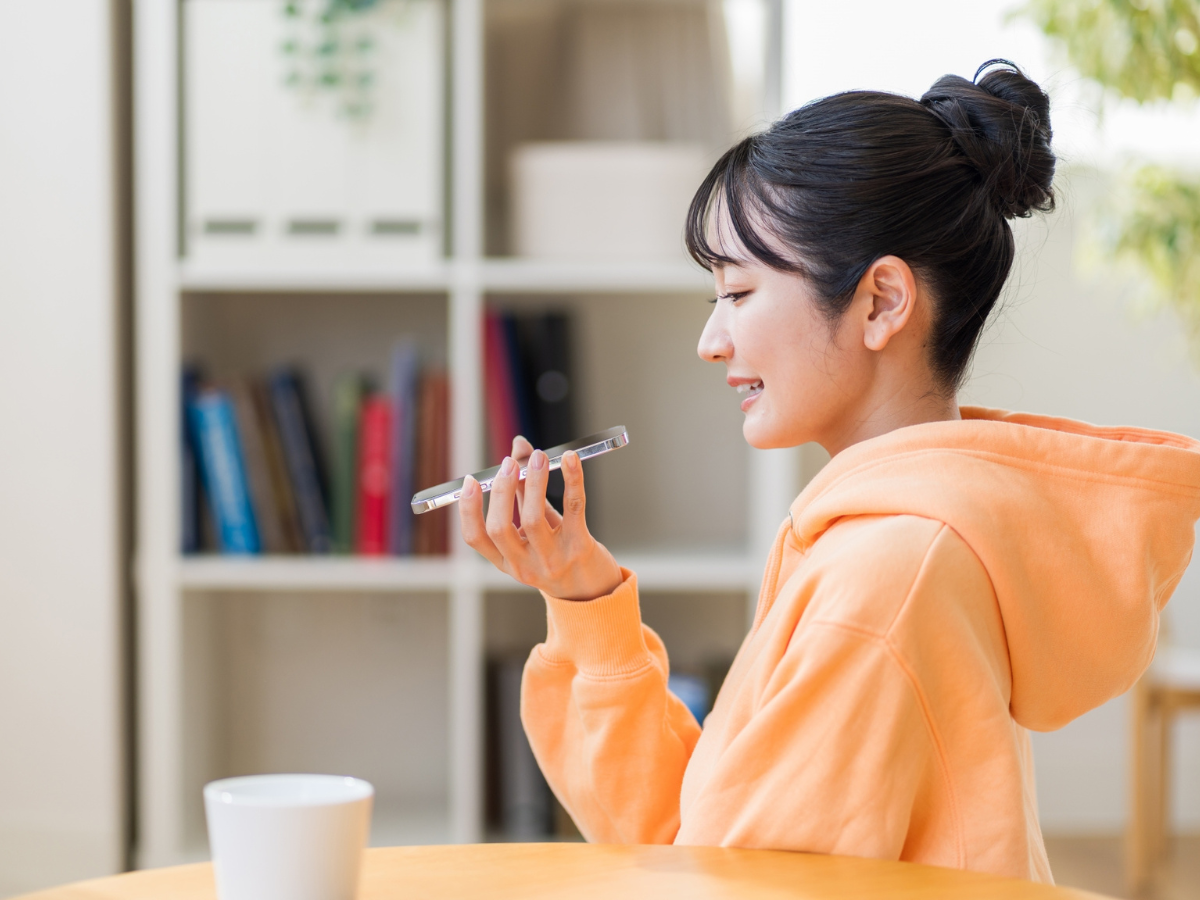 スマートフォンでシャドーイングする20代の女性