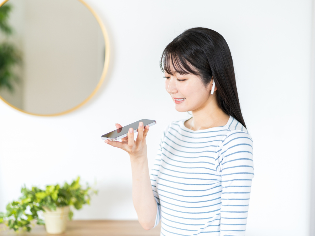 スマートフォンでシャドーイングする20代の女性